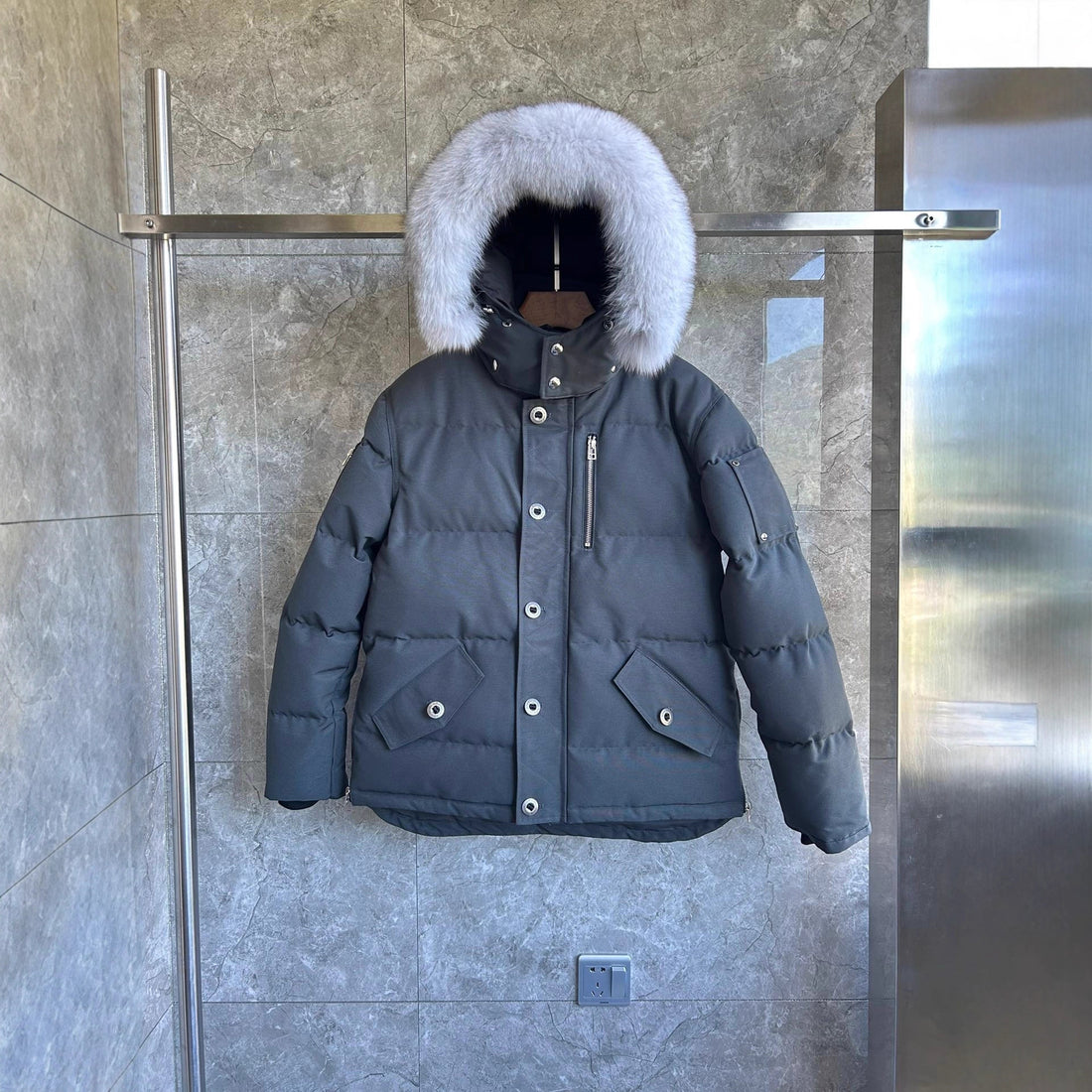 Black puffer coat with coyote fur-trimmed hood and silver hardware